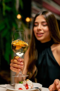 İtalyan restoranındaki bir randevuda pahalı bir şarap içen genç ve tatlı bir kızın yakın çekimi.