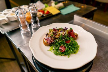 İtalyan restoranının profesyonel mutfağında pişirilmiş jambonlu ve krem peynirli bruschetta.