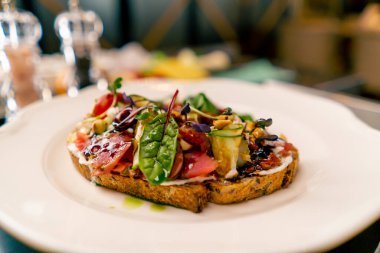İtalyan restoranının profesyonel mutfağında pişirilmiş jambonlu ve krem peynirli bruschetta.