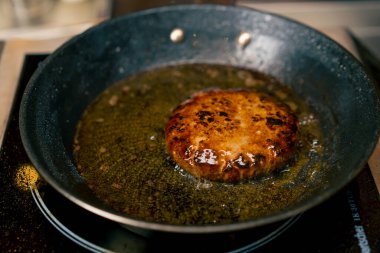 İtalyan restoranının profesyonel mutfağında köfte için köfte kızartan bir şefin yakın çekimi.