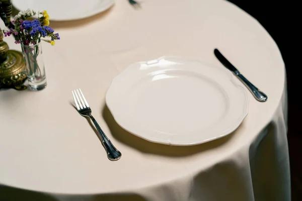A close-up of beautifully reserved table at an expensive Italian restaurant being beautifully set up by waiters