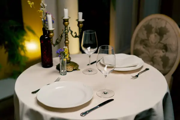 A close-up of beautifully reserved table at an expensive Italian restaurant being beautifully set up by waiters