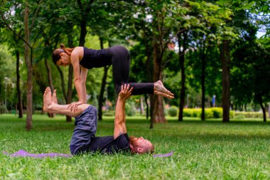 aşık çift veya yoga eğitmeni ve şehir parkında egzersiz yapan kadın sağlıklı vücut kasları destekliyor.