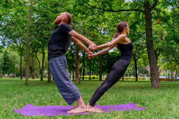 aşık çiftler ya da yoga hocası ve kadın şehir parkında egzersiz yapıyorlar.