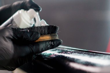 Oto yıkama işçisi plastik köpük uygularken ayrıntılı işlem sırasında lüks bir arabanın kapı kartını temizlerken yakın plan.