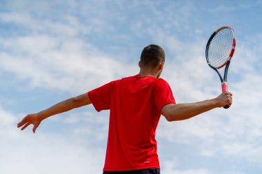 Şampiyonluktan sonra profesyonel tenis oyuncusunun portresi ya da tenis kortunun raketi arka planda.