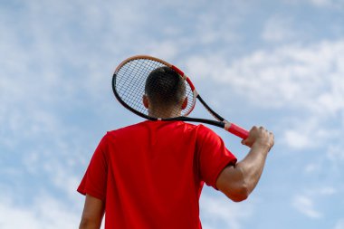 Şampiyonluktan sonra profesyonel tenis oyuncusunun portresi ya da tenis kortunun raketi arka planda.