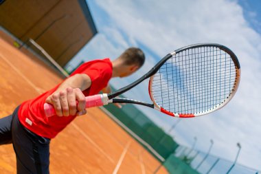 Genç profesyonel oyuncu koçu raket ve tenis topuyla tenis kortu antrenmanı yapıyor.