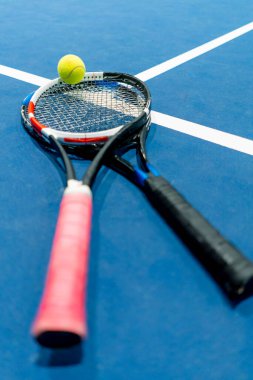 Spor ekipmanları tenis topu ve raket kapalı alanda profesyonel mavi kort hobisi olan spor müsabakaları düzenliyor.