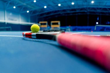 Spor ekipmanları tenis topu ve raket kapalı alanda profesyonel mavi kort hobisi olan spor müsabakaları düzenliyor.