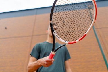 Genç tenis oyuncusu antrenörü tenis kortunda raketle topa vuruyor ve spor yaşam tarzı yarışmasına hazırlanıyor.