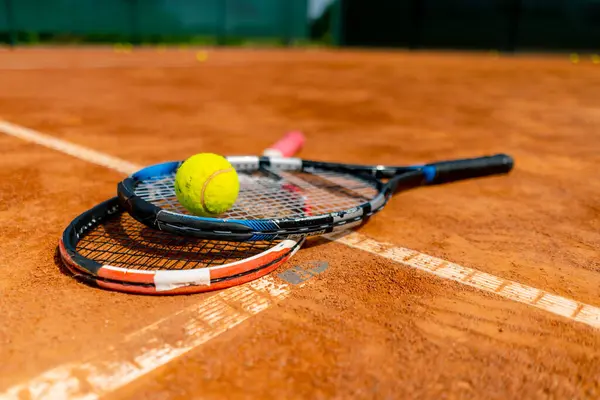 close-up of sports equipment, tennis rackets and balls lie an outdoor ground court hobby competition sport