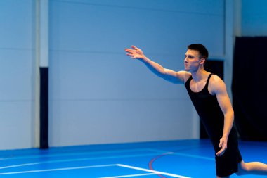 Genç şişirilmiş sporcu voleybol maçı ya da maç sırasında topa servis yapmaya hazırlanıyor.