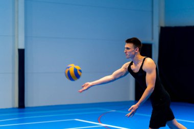 Genç şişirilmiş sporcu voleybol maçı ya da maç sırasında topa servis yapmaya hazırlanıyor.