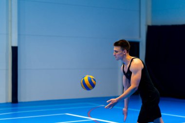 Genç şişirilmiş sporcu voleybol maçı ya da maç sırasında topa servis yapmaya hazırlanıyor.