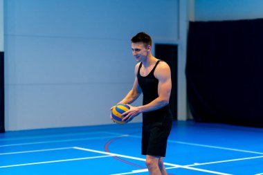 Genç şişirilmiş sporcu voleybol maçı ya da maç sırasında topa servis yapmaya hazırlanıyor.