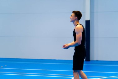 Genç şişirilmiş sporcu voleybol maçı ya da maç sırasında topa servis yapmaya hazırlanıyor.