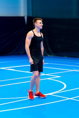 Genç şişirilmiş sporcu voleybol maçı ya da maç sırasında topa servis yapmaya hazırlanıyor.