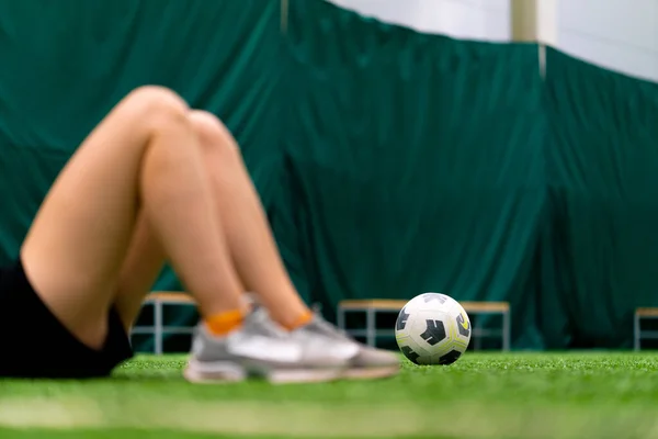ボールスポーツトレーニング活動の背景にあるサッカーグリーンフィールドの女性サッカー脚 — ストック写真