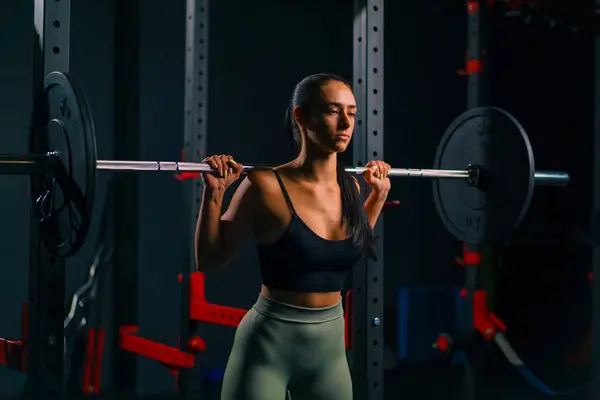 专注的健身女子与杠铃体操训练肌肉组进行重大肩压运动的肖像 — 图库照片