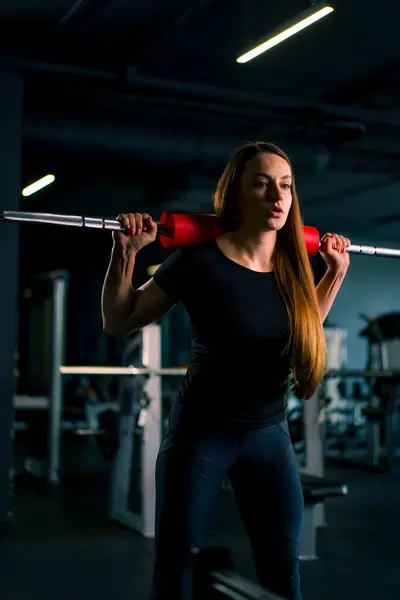 ジムトレーニング筋肉グループのバーベルで重い肩のプレス練習をしている集中フィットネス女性の肖像画 — ストック写真