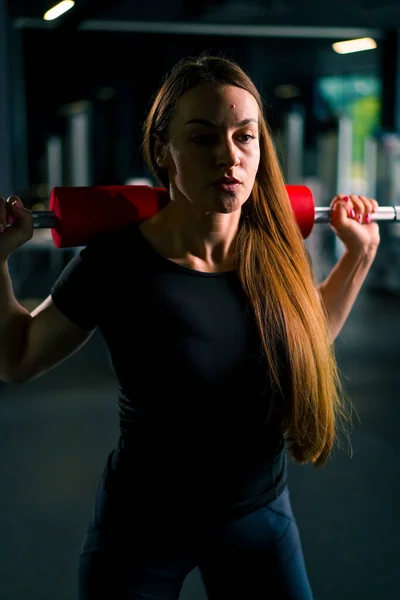 ジムトレーニング筋肉グループのバーベルで重い肩のプレス練習をしている集中フィットネス女性の肖像画 — ストック写真