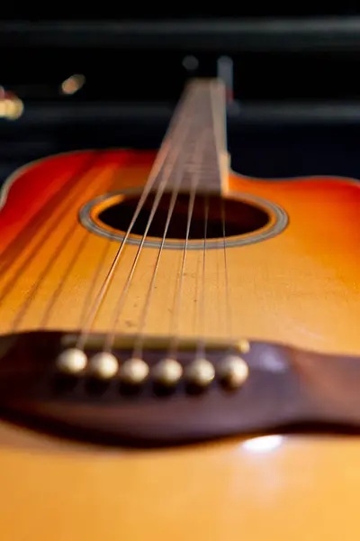 音楽スタジオで壁にぶら下がっている木製の古典的なアコースティックギターの弦のクローズアップショット — ストック写真
