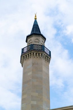 Müslüman camisinde balkonlu bir minare kulesinin parlak mavi gökyüzüne yakın çekim görüntüsü.