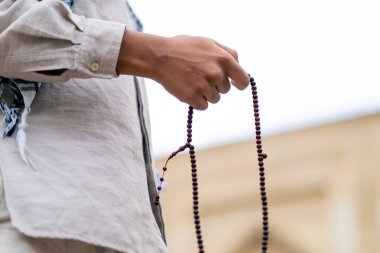 Dönüşüm ve Allah 'a ibadet sırasında tespih tutan Müslüman bir adamın elleri.