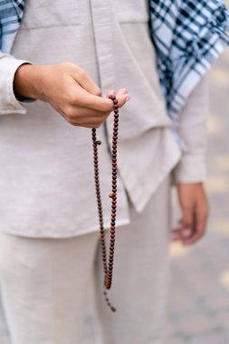 Dönüşüm ve Allah 'a ibadet sırasında tespih tutan Müslüman bir adamın elleri.