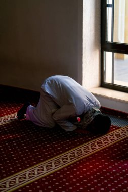 Bir mü 'min, cami camiinin camının kenarında diz çöker, alnını halıya koyar ve Allah' a tevbe eder.