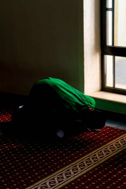 Bir mü 'min, cami camiinin camının kenarında diz çöker, alnını halıya koyar ve Allah' a tevbe eder.