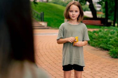 Şehir parkında küçük şekerlemeler yiyen güzel bir kız portresi Mutlu tasasız bir çocukluk