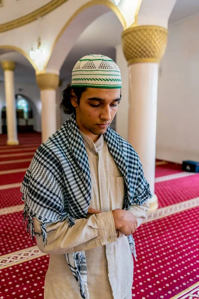 アラビアの服を着た若いムスリム男性が ラマダンの休日の間にモスクで祈ります — ストック写真