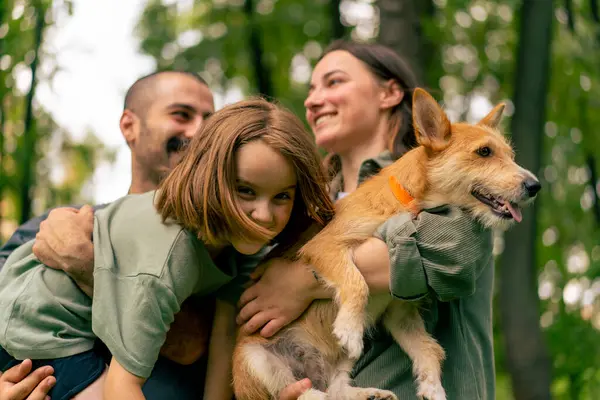 portrait happy young family in park with dog dad holding daughter in arms concept trust care and family values