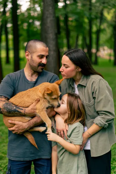 portrait of happy young family in park with dog dad mom daughter resting concept trust care and family values