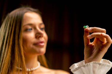 Genç ve güzel bir kız, üretime başlamadan önce kolye ya da küpe için boncukları dikkatlice inceliyor.