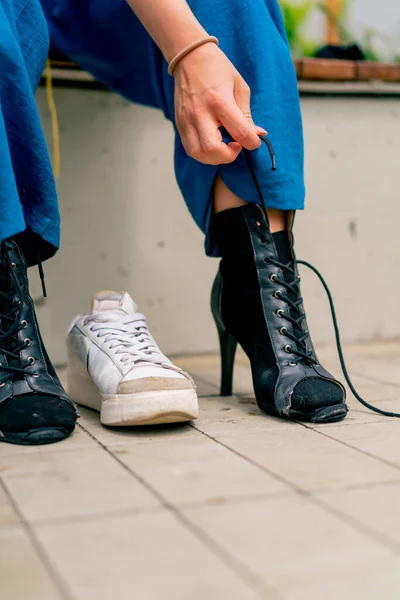 close-up of dancer's legs in black high-heeled shoes girl tying shoelaces on street sexuality