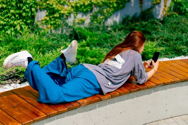 Young Girl Lying Park Bench Phone Her Hands She Texting — Stock Photo, Image