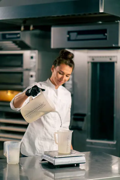 Chef Feminino Derramando Água Copo Medição Uma Balança Cozinha Uma — Fotografia de Stock