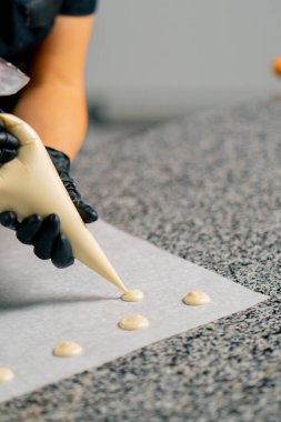 Çikolatanın pasta poşetinden çıkarılıp doğal şeker şekeri şekline dönüştürüldüğü yakın plan bir pastanede parşömen üzerinde.