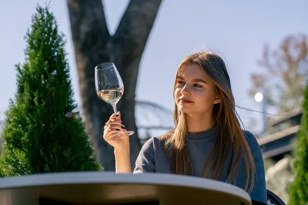 Una Ragazza Adulta Siede Tavolo Giardino Con Bicchiere Vino Assaggia — Foto Stock