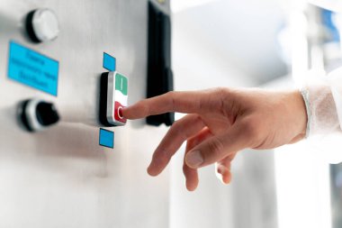 Bir adamın fermantasyon makinesinin açma ve kapama düğmesine parmaklarıyla bastığı yakın çekim.