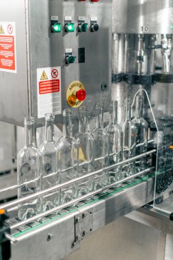 Şeffaf camdan yapılmış boş şişeler şişeleme ve ambalaj şarabı için sıraya dizilmiştir.