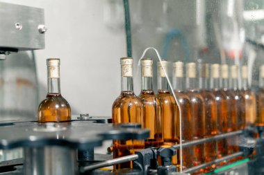 Şaraphanedeki ambalaj hattı boyunca şarap dolu şişeler depolama için mahzenlere daha fazla dağıtılmak üzere taşınır.