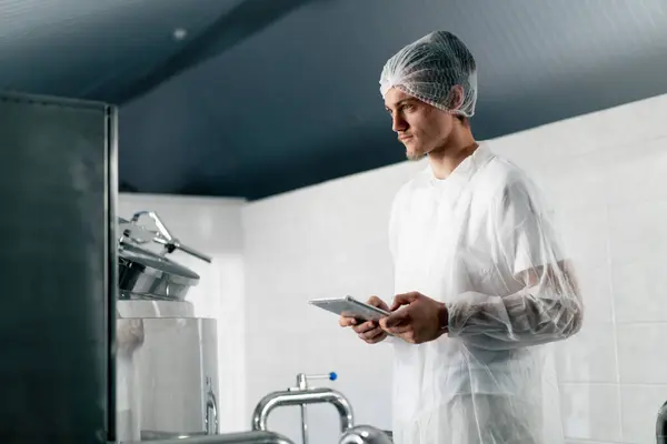 Male Technologist White Protective Suit Headgear Checks Production Stage Drink — Stock Photo, Image