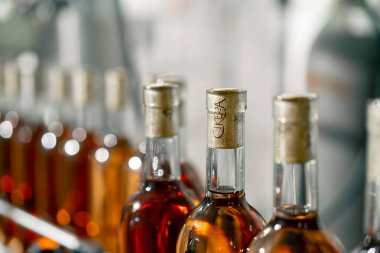 Şarap dolu mühürlü şişelerin yakın çekim görüntüleri mahzendeki depo için şaraphanenin ambalaj hattı boyunca ilerliyor.