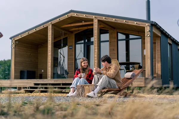 Terasta, büyük bir evin yanında birbirine aşık bir çift, tahta koltuklarda çay içip birbirleriyle iletişim kurarlar.