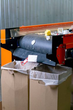 Kullanılmış plastik ve kağıt çöplerinin yakın çekim görüntüleri bir atık geri dönüşüm istasyonunun sıralama hattında yatıyor