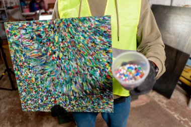 Parçalanmış geri dönüşümlü plastik kaplardan yapılmış bir resmin yakın plan fotoğrafı.